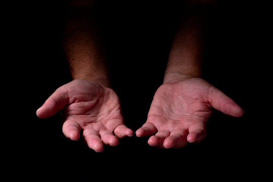 Male Hands Emerging From The Darkness. Hands On A Black Background.