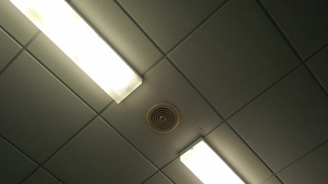 White plastic tiled clinic waiting room ceiling lighting rotating strangely