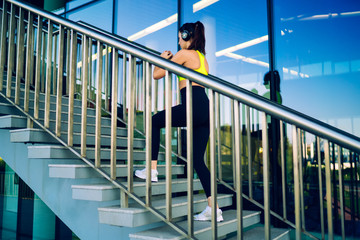 Focused athletic woman warming up on stairs