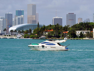 View of a small luxury ground charter yacht on Biscayne Bay against a background of Star Island...