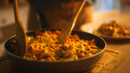Person Serving Delicious Looking Pasta on the Plate. Serving Profesionally Cooked Pasta Dish in the Restaurant or for Romantic Dinner Meal at Home. Close-up Shot