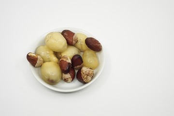 Matoa fruits and dried seeds from Papua, Indonesia in a small bowl with a white background from high angle view