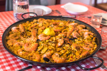 Paella with seafood. A dish for the company. Home cuisine restaurant. Spanish cuisine. Travel to Europe. Traditional Spanish food. Mussels and shrimps. Delicious dinner.