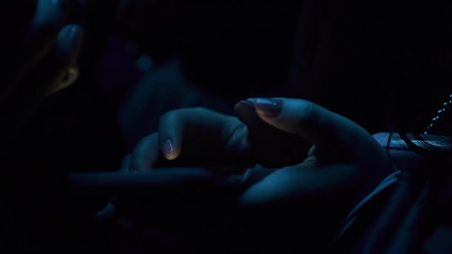 Asian girl interacting with a smartphone in the twilight