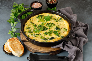 Omelette with green vegetables, broccoli and green pea in a frying pan.