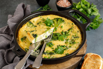 Omelette with green vegetables, broccoli and green pea in a frying pan.