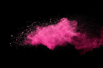 Pink powder explosion on black background. Paint Holi.