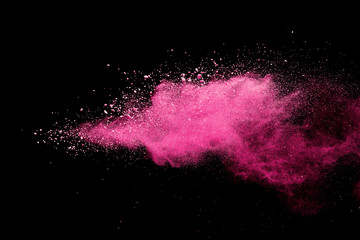 Pink powder explosion on black background. Paint Holi.