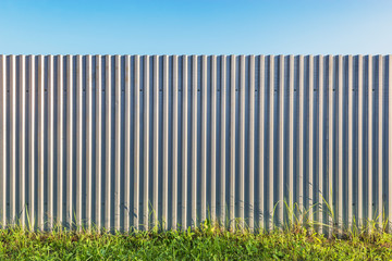 Gray metallic vertical material wall background at sunset.