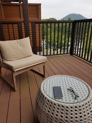 Fototapeta na wymiar 高原リゾートでの休日 もしくはテレワーク イメージ　wooden deck chair and table