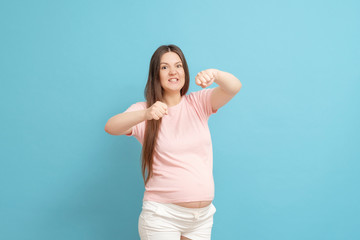 very aggressive pregnant woman on blue background