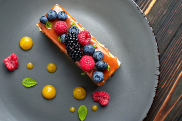 One piece of pie, honey cake with fresh berries, mint, and caramel