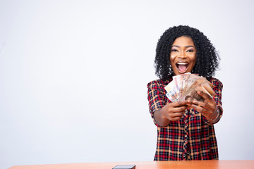 pretty black woman holding some cash feeling excited and happy
