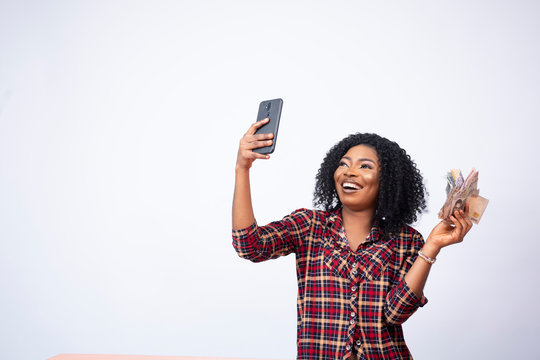 pretty black lady taking a selfie with a wad of cash