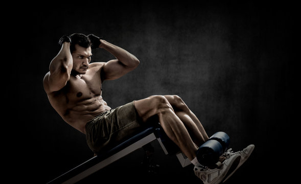 man bodybuilder perform exercise on prelum abdominale on bench