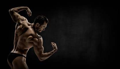 Obraz premium man - bodybuilder pose on black background