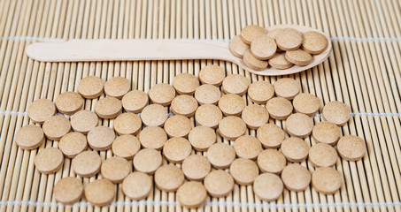 Alternative medicine tablets on a wooden spoon