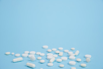 White medical pills on blue background.