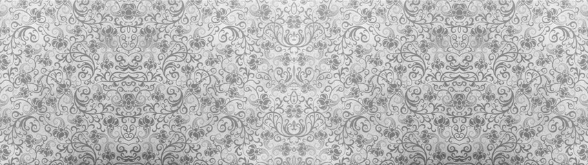 Old gray vintage worn shabby seamless patchwork tiles stone concrete cement wall texture wide background banner panorama wallpaper, with flower leaves print