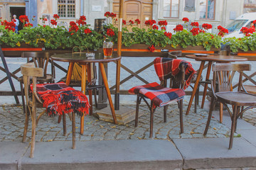 blankets on chairs, summer terrace in autumn. 
outdoor cafe tables and chairs