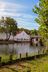Obraz premium Margens do rio Nabão com a ponte velha ao fundo em Tomar.