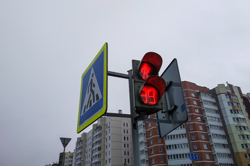 Red traffic light for pedestrians close up on background of building