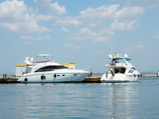 Two luxury yachts wait in the port