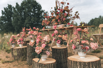 Pink flower arrangement on logs for a wedding