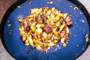 Traditional fried potatoes with pork in a skillet