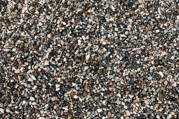 Top view over gray and brown pebble on a beach.
