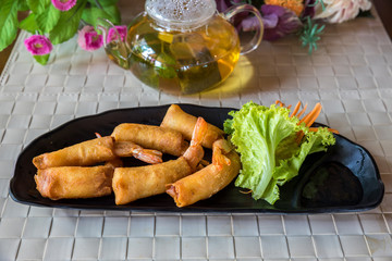 Fried chinese spring rolls with sweet chili sauce. Deep fried spring rolls and vegetables on plate.