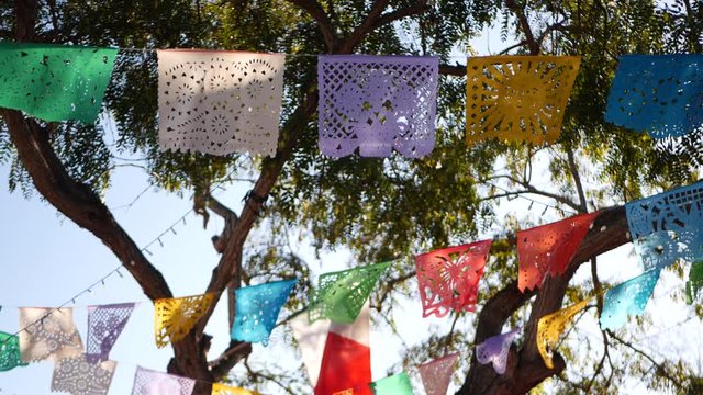 Colorful mexican perforated papel picado banner, festival colourful paper garland. Multi colored hispanic folk carved tissue flags, holiday or carnival. Authentic fiesta decoration in Latin America.