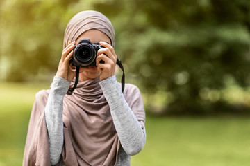 Unrecognizable muslim woman photographer taking photos outdoors