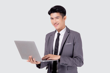 Young asian business man standing work on laptop computer to internet online isolated on white background, businessman confident and notebook, freelance with success, marketing and communication.