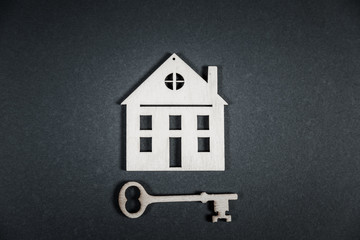 Fototapeta na wymiar Real estate concept. Small toy wooden house with keys on grey background