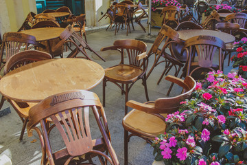 Tables and chairs in empty  restaurant.
Open outdoors cafe with chairs and tables.