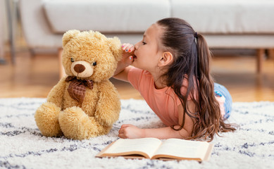 Asian Kid Girl Sharing Secret With Teddy Bear At Home