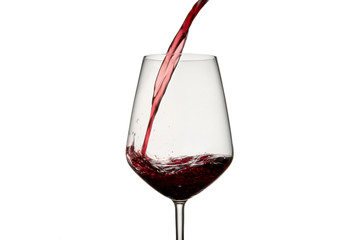 Close-up of a bottle of red wine that is poured into a glass piercing some waves on a white background