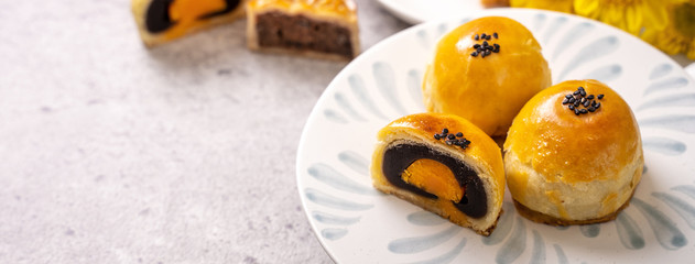 Tasty baked egg yolk pastry moon cake for Mid-Autumn Festival on bright cement table background....