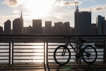 Bicycle on a Railing along the East River at Gantry Plaza State Park in Long Island City Queens during a Sunset with the Manhattan Skyline