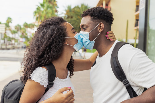 Young couple kissing while wearing face surgical mask during coronavirus outbreak. Relationship and Covid 19 concept. Image