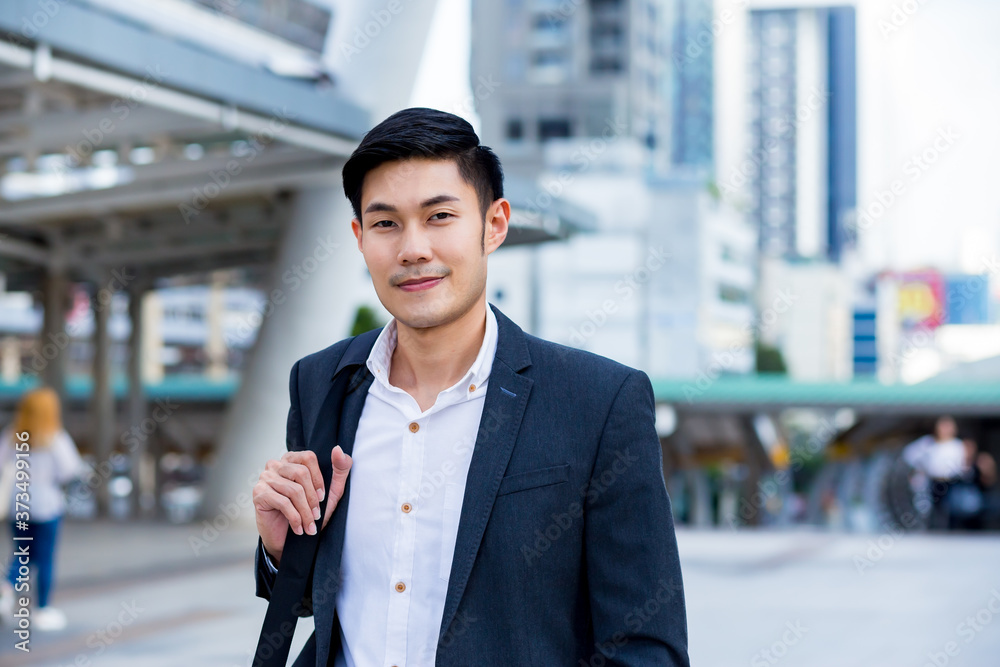 Wall mural a young cinfident businessman smiling in the city concept business man