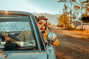Blonde girl and vintage car in nature
