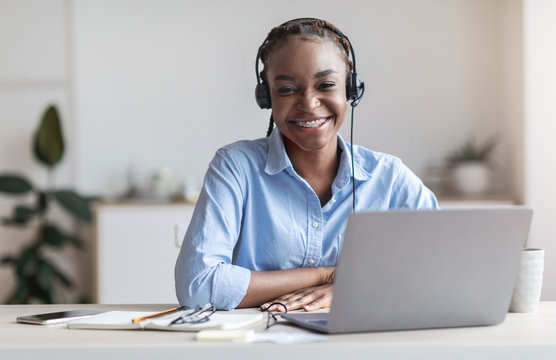 Portrait Of Smiling Black Woman Call Center Operator At Workplace In Office