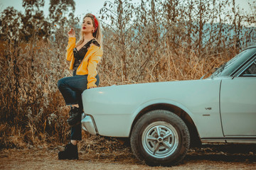 Fototapeta na wymiar Blonde girl and vintage car in nature