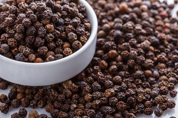 fragrant black pepper on white acrylic background