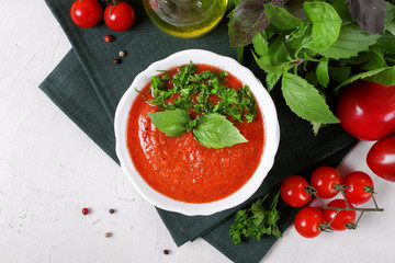 Tomato gazpacho soup in a ceramic bowl topped with basil leaves. Spanish cuisine cold soup