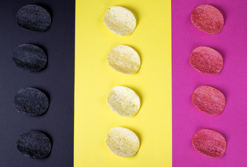 Multicolored potato chips against the geometric background