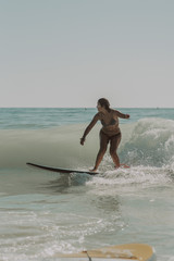 Chica joven y guapa surfeando en playas de Cadiz