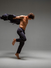 Stylish young man dancer in suit and barefoot dancing expressive dance. Dance school poster